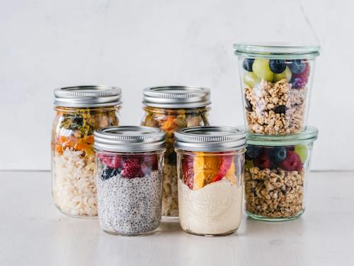 Free Six Fruit Cereals in Clear Glass Mason Jars on White Surface Stock Photo